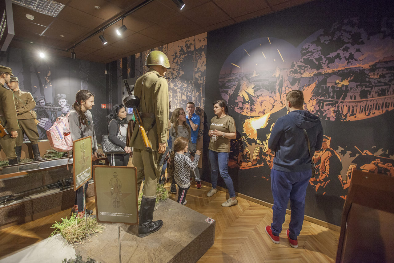 Grupa uczniów słucha przewodnika muzeum.