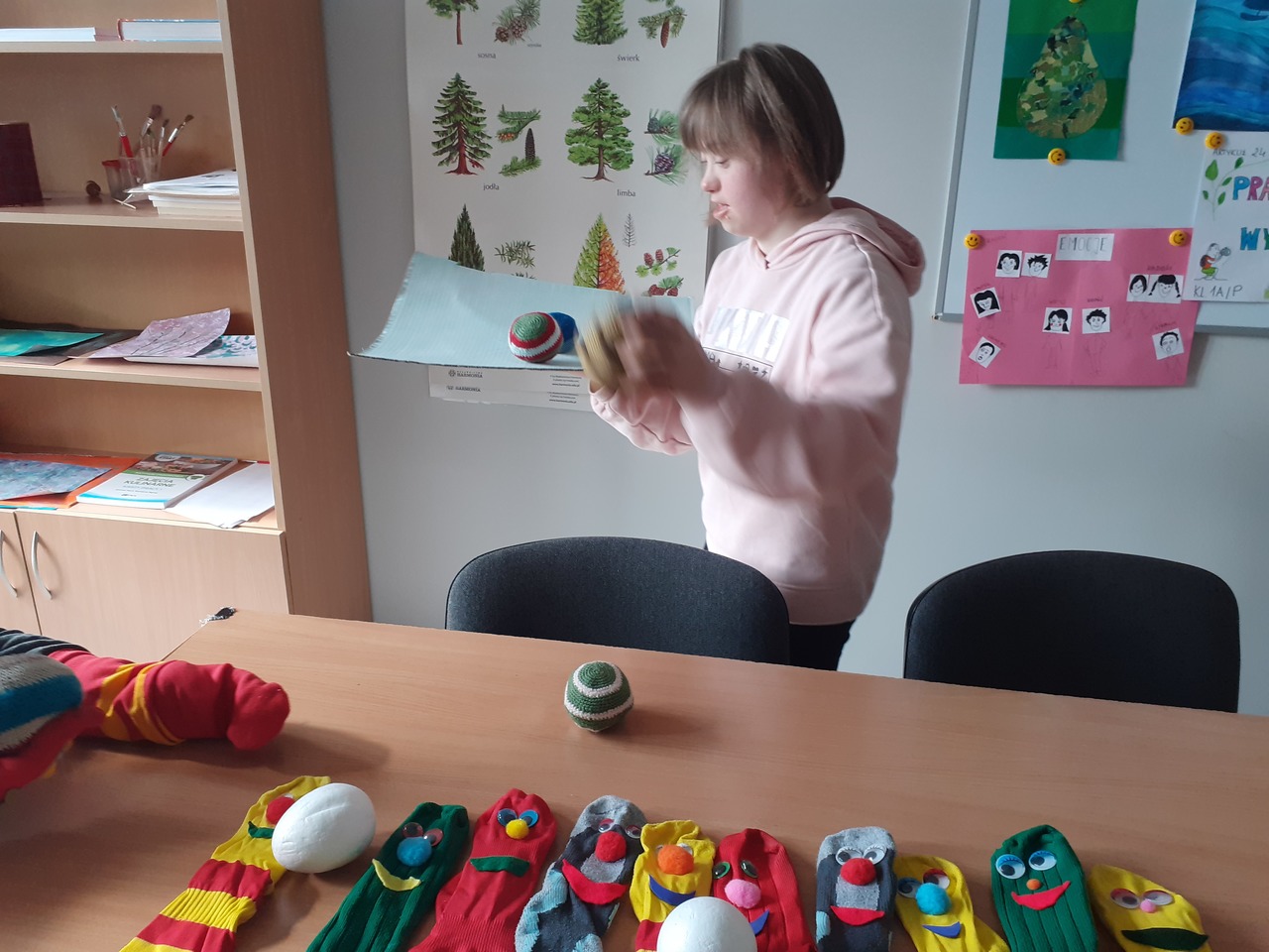 Uczennica przenosi piłki na tekturowej tacy dokładając kolejne na  wyznaczonych przystankach. Balansuje, aby nie upuścić piłek.