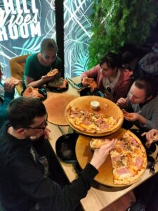 Grupa uczniów jedząca pizze