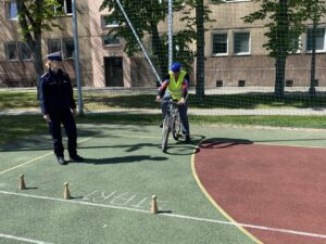 Zawodnik w asyście policjantki rozpoczyna trasę przejazdu po torze sprawnościowym