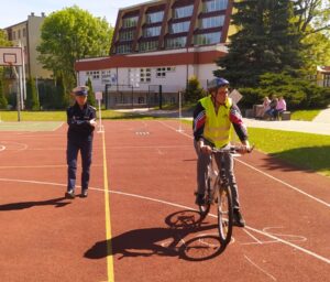 Zawodnik w asyście policjantki pokonuje trasę przejazdu po torze sprawnościowym