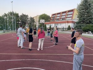 Grupa uczniów grających w piłkę na boisku szkolnym