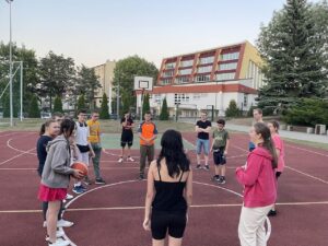 Grupa uczniów grających w piłkę na boisku szkolnym