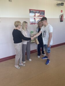 Uczniowie odbierający dyplomy i nagrody za udział w konkursie geograficznym i Turnieju Mistrza Nauk Przyrodniczych oraz nauczyciele wręczający nagrody i dyplomy.