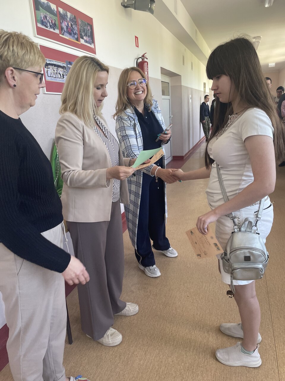Uczniowie odbierający dyplomy i nagrody za udział w konkursie geograficznym i Turnieju Mistrza Nauk Przyrodniczych oraz nauczyciele wręczający nagrody i dyplomy.