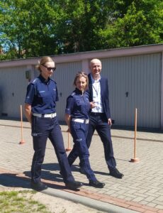 Panie policjantki z koordynatorem spacerujący po torze sprawnościowym,