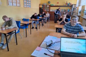Uczniowie piszą test z wiedzy o ruchu drogowym w sali dydaktycznej.