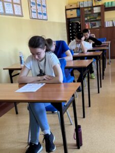 Zawodnicy piszący Test z wiedzy o ruchu drogowym w Sali dydaktycznej,