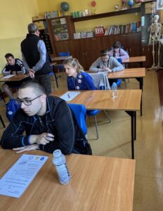 Zawodnicy piszący Test z wiedzy o ruchu drogowym w Sali dydaktycznej,