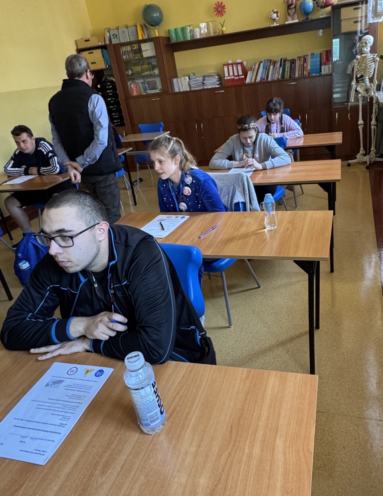 Zawodnicy piszący Test z wiedzy o ruchu drogowym w Sali dydaktycznej,