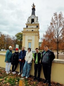 Młodzież pozuje do zdjęcia na tle Bramy Wielkiej „Gryf”                  prowadzącej  do Pałacu Branickich.
