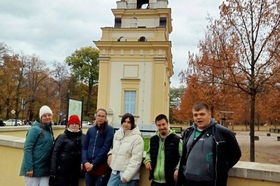 Młodzież pozuje do zdjęcia na tle Bramy Wielkiej „Gryf” prowadzącej do Pałacu Branickich.