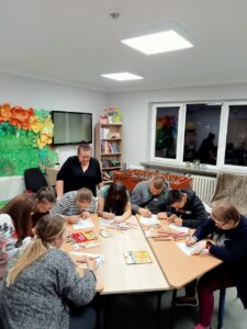 Wychowawczyni p. Jola obserwuje młodzież rysującą kolorami emocje
