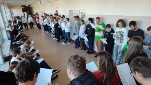 Grupa uczniów śpiewa Hymn Polski