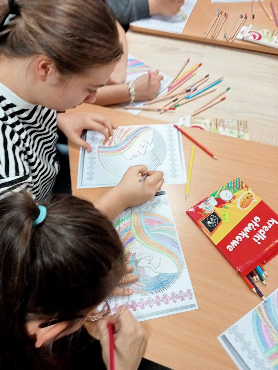 Dwie dziewczyny kolorują swoje obrazki