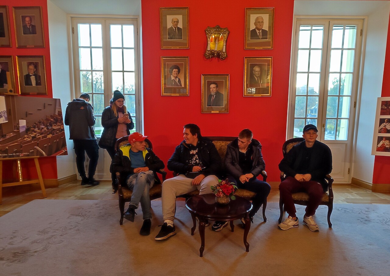 Młodzież odpoczywa we wnętrzach Pałacu Branickich. W tle widać wiele obrazów związanych z tematyką tego miejsca.
