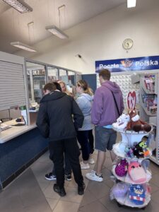 Zd.1 Młodzież uczy się, w jaki sposób nadać przesyłkę na poczcie.