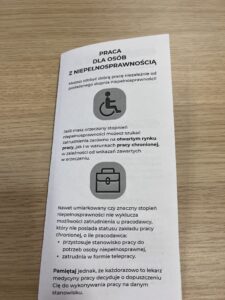 Zdj. 4 - na stole leży ulotka z informacją o możliwościach pracy dla osób z niepełnosprawnościami.
