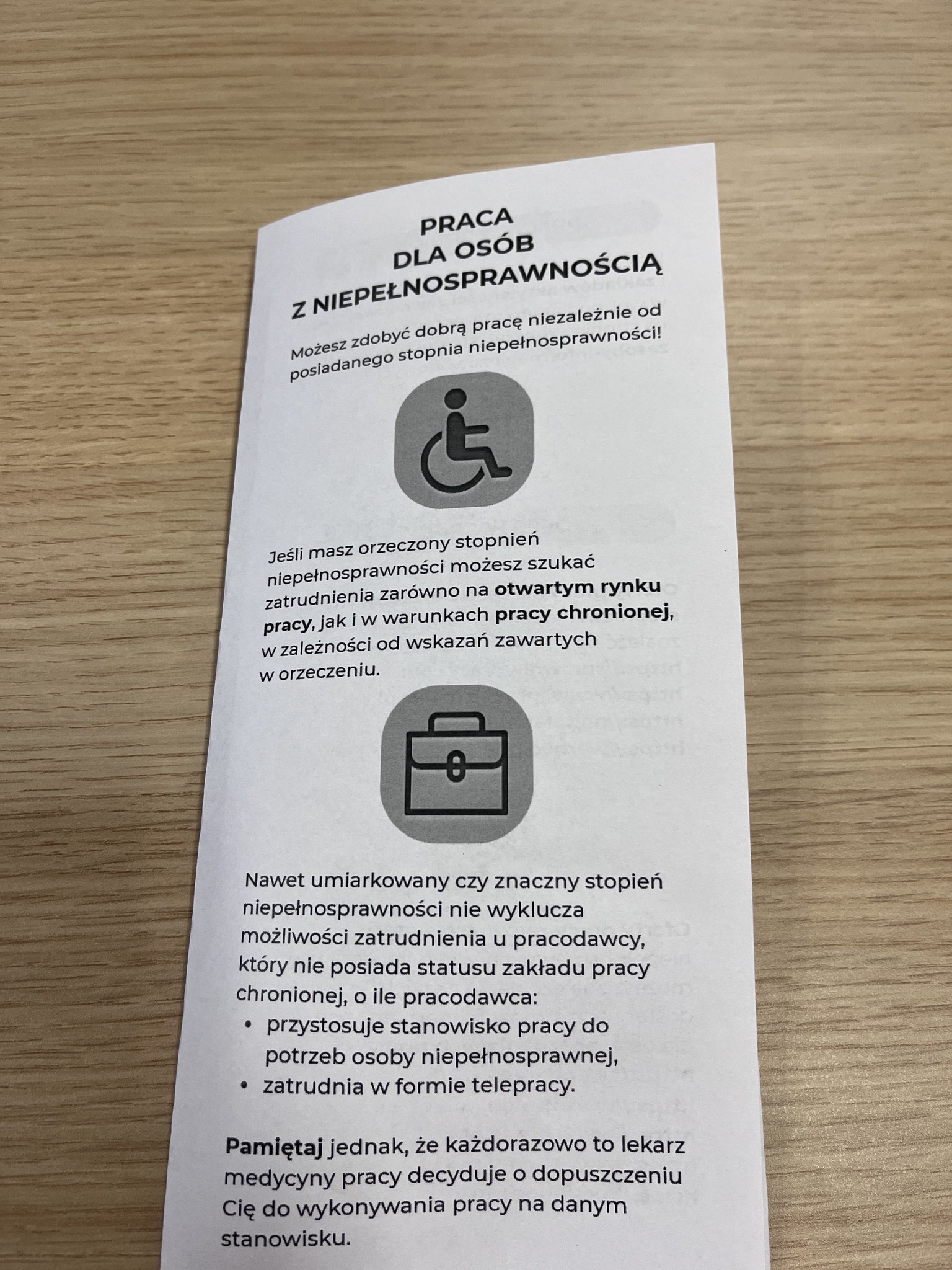 Zdj. 4 - na stole leży ulotka z informacją o możliwościach pracy dla osób z niepełnosprawnościami.
