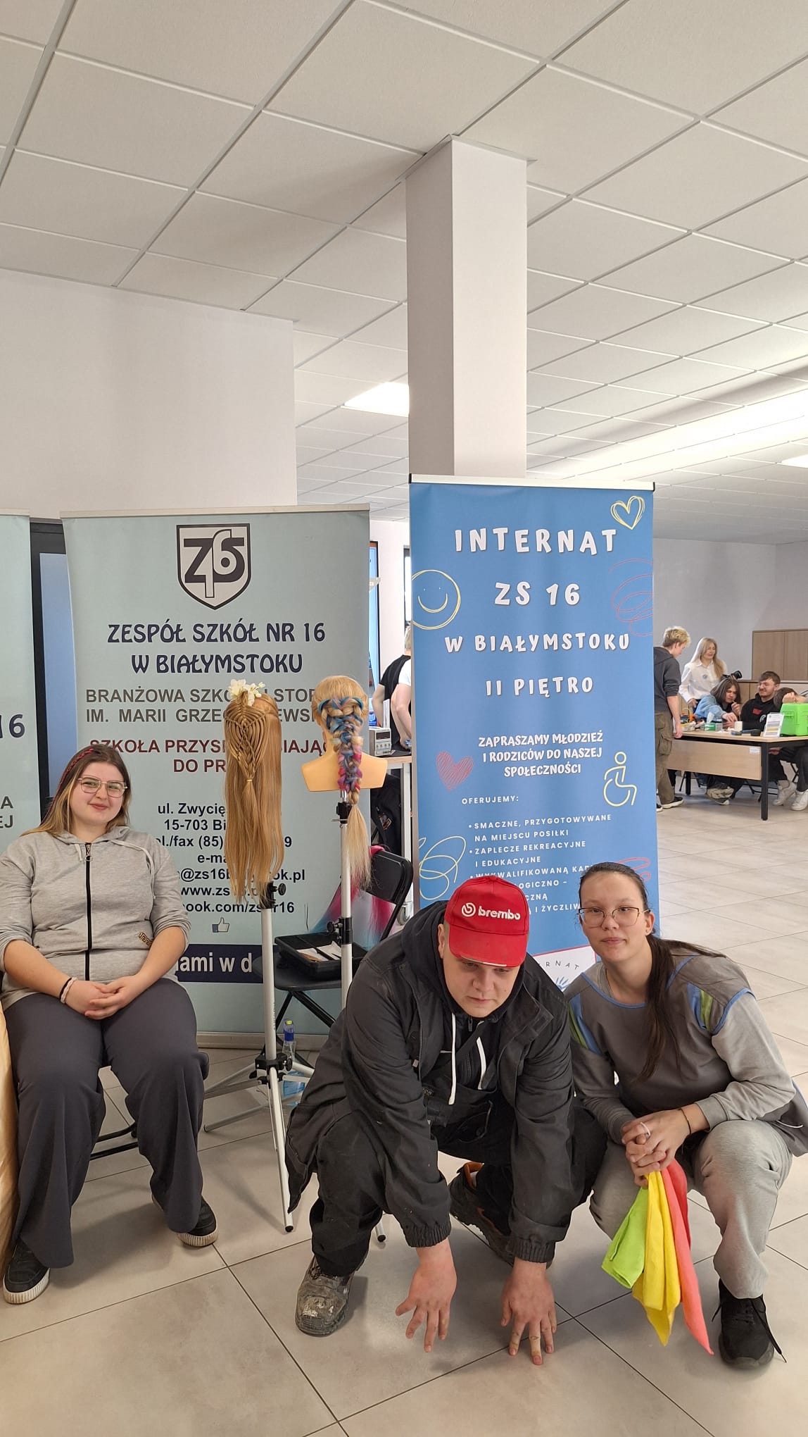 Wychowankowie stoją przy rolerze reklamującym internat ZS nr16 i dumnie reprezentują swój internat.