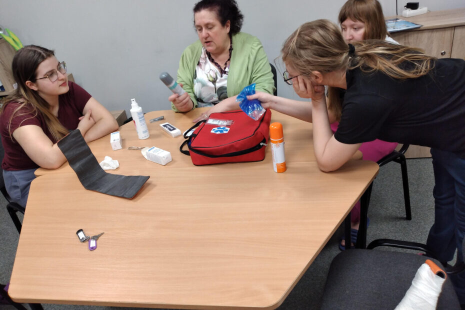 Wychowawczyni tłumaczy wychowankom zasady udzielania pierwszej pomocy.