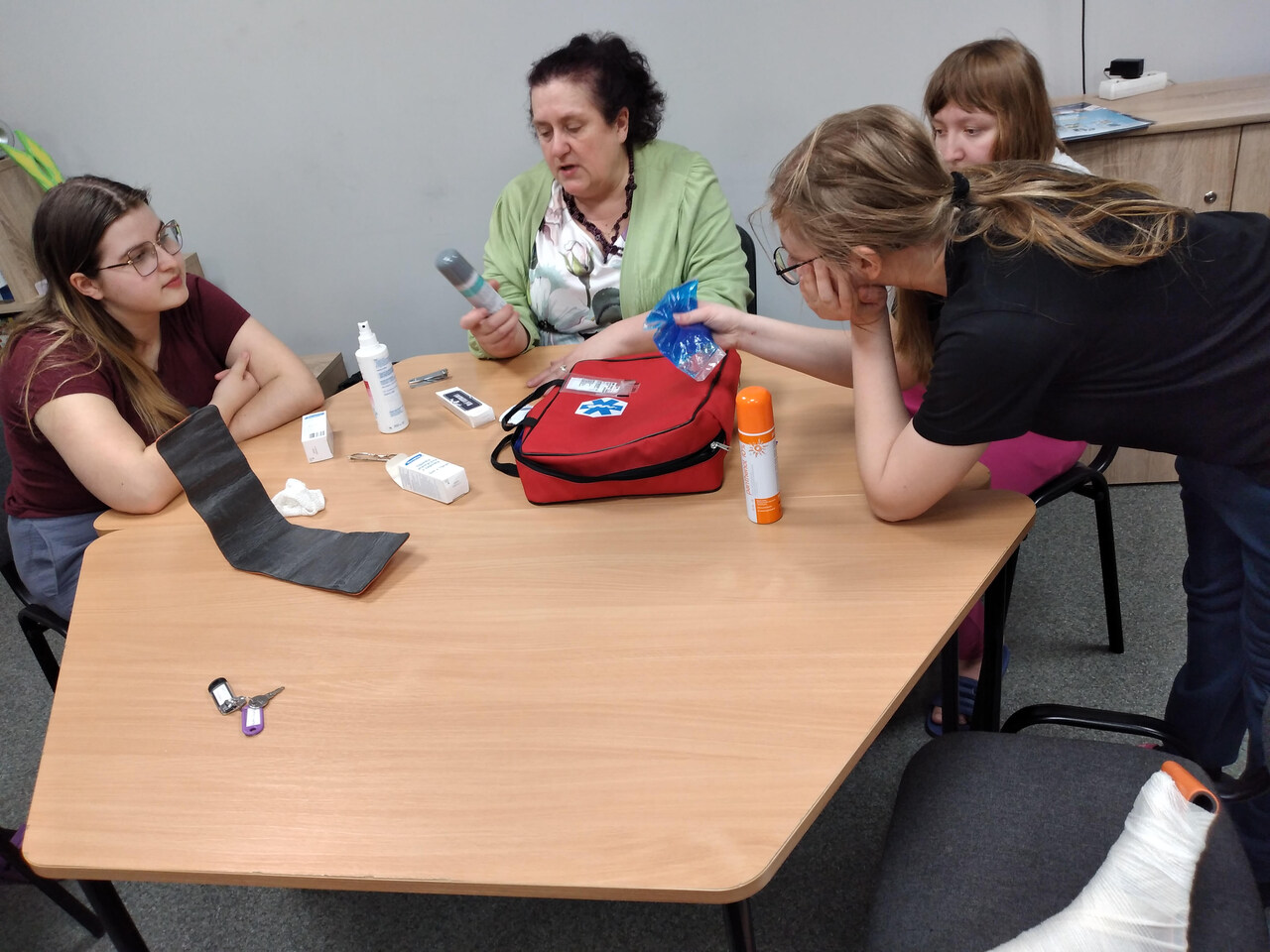 Wychowawczyni tłumaczy wychowankom zasady udzielania pierwszej pomocy. 