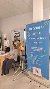 Wychowankowie stoją przy rolerze reklamującym internat ZS nr16 i dumnie reprezentują swój internat.