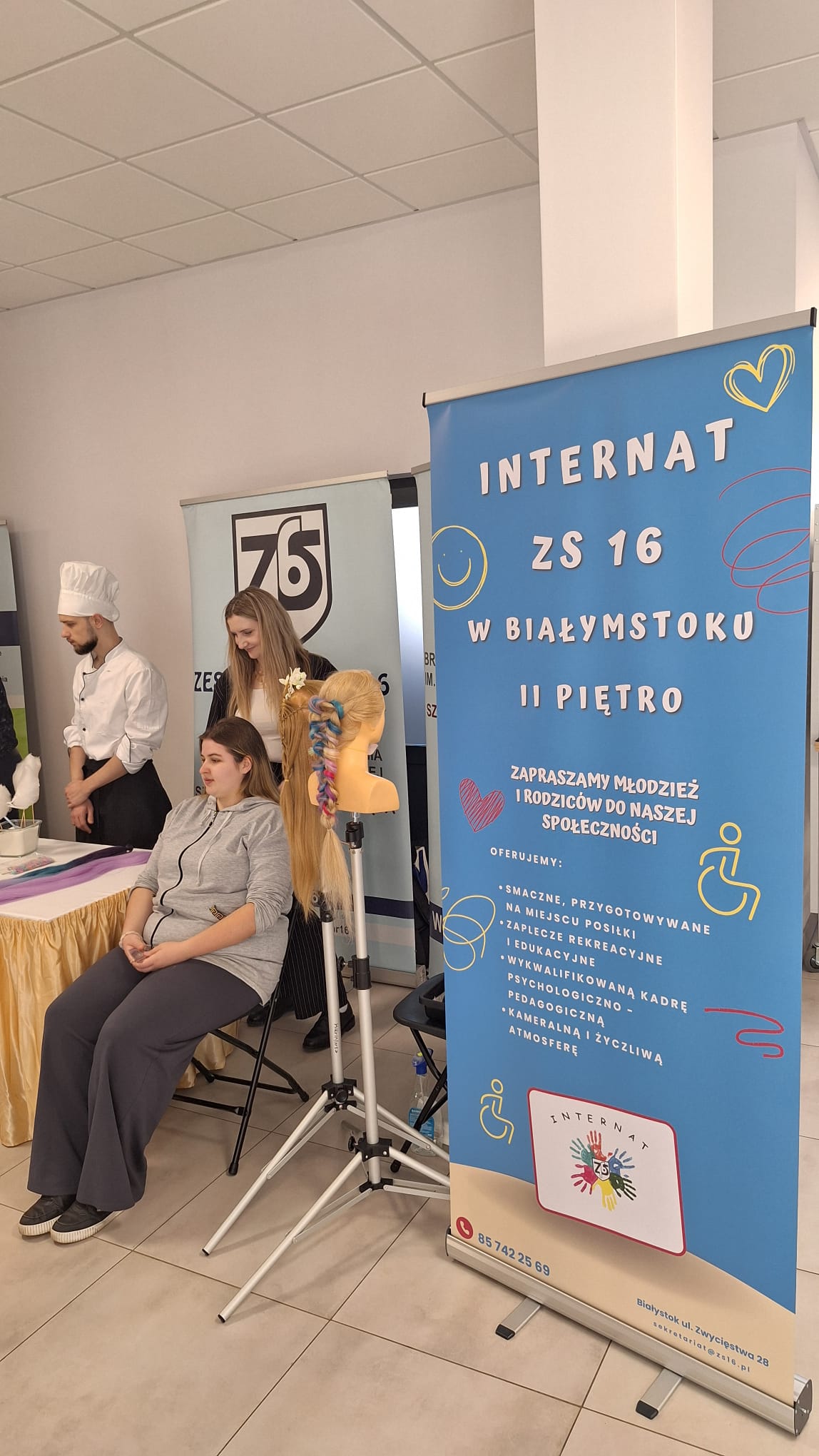 Wychowankowie stoją przy rolerze reklamującym internat ZS nr16 i dumnie reprezentują swój internat.