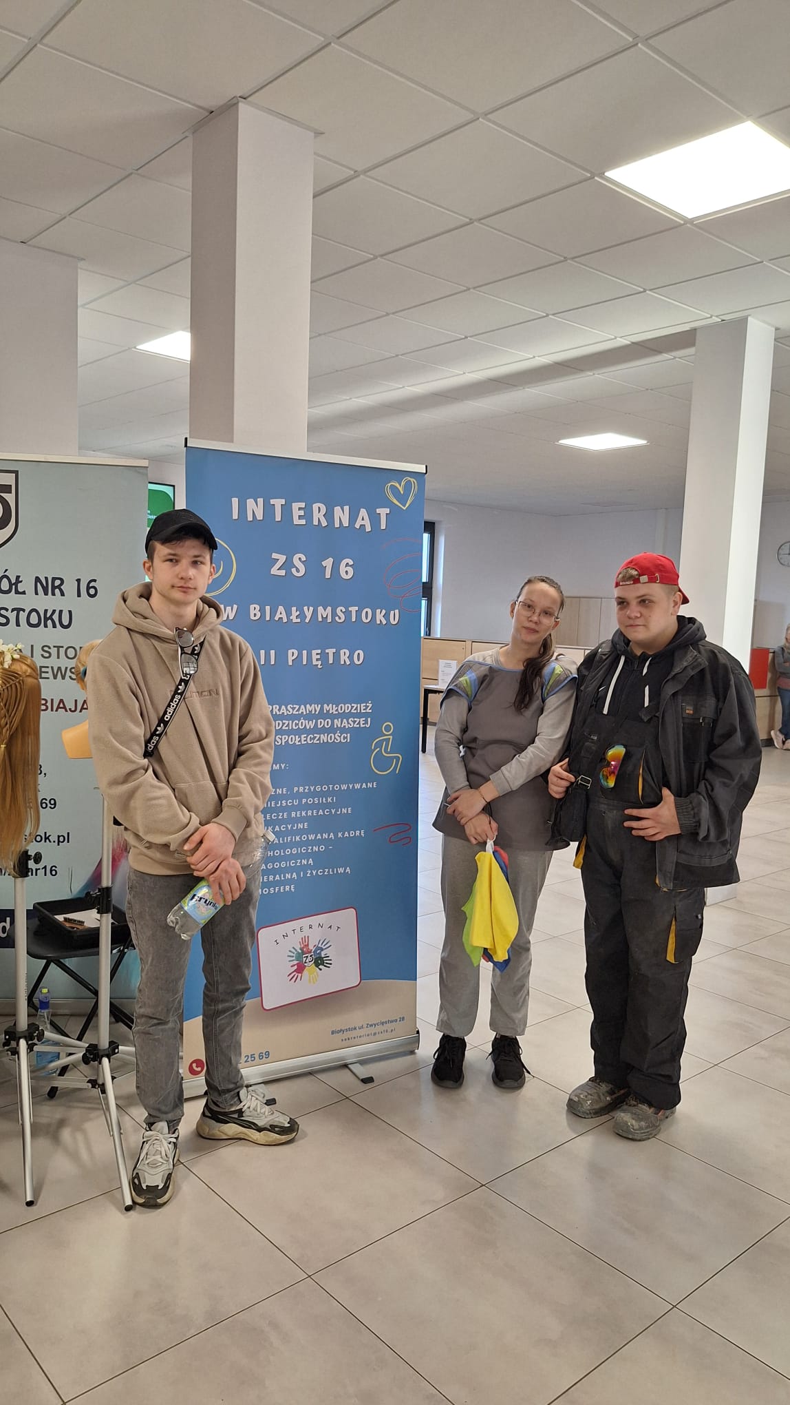 Wychowankowie stoją przy rolerze reklamującym internat ZS nr16 i dumnie reprezentują swój internat.