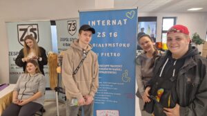 Wychowankowie stoją przy rolerze reklamującym internat ZS nr16 i dumnie reprezentują swój internat.
