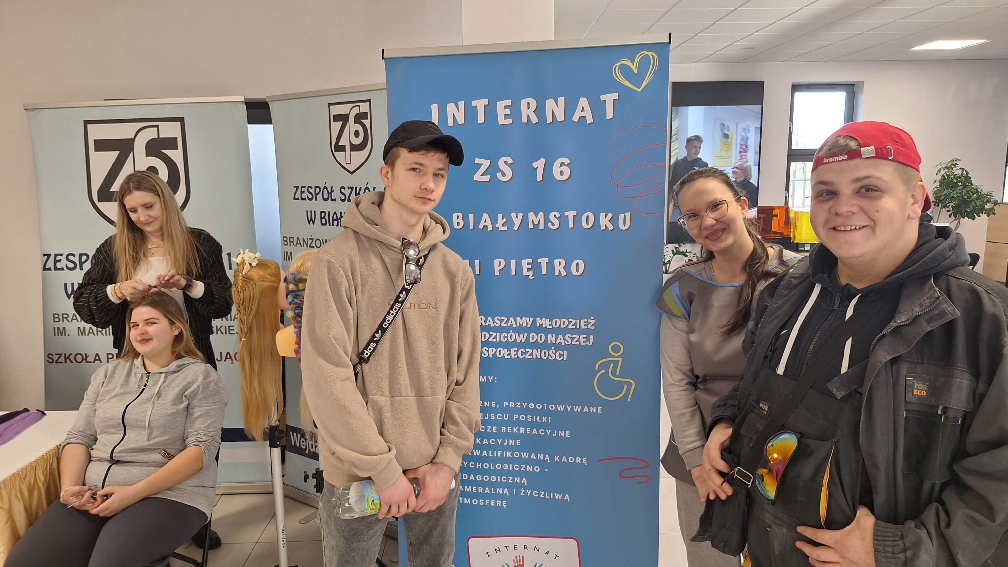 Wychowankowie stoją przy rolerze reklamującym internat ZS nr16 i dumnie reprezentują swój internat.