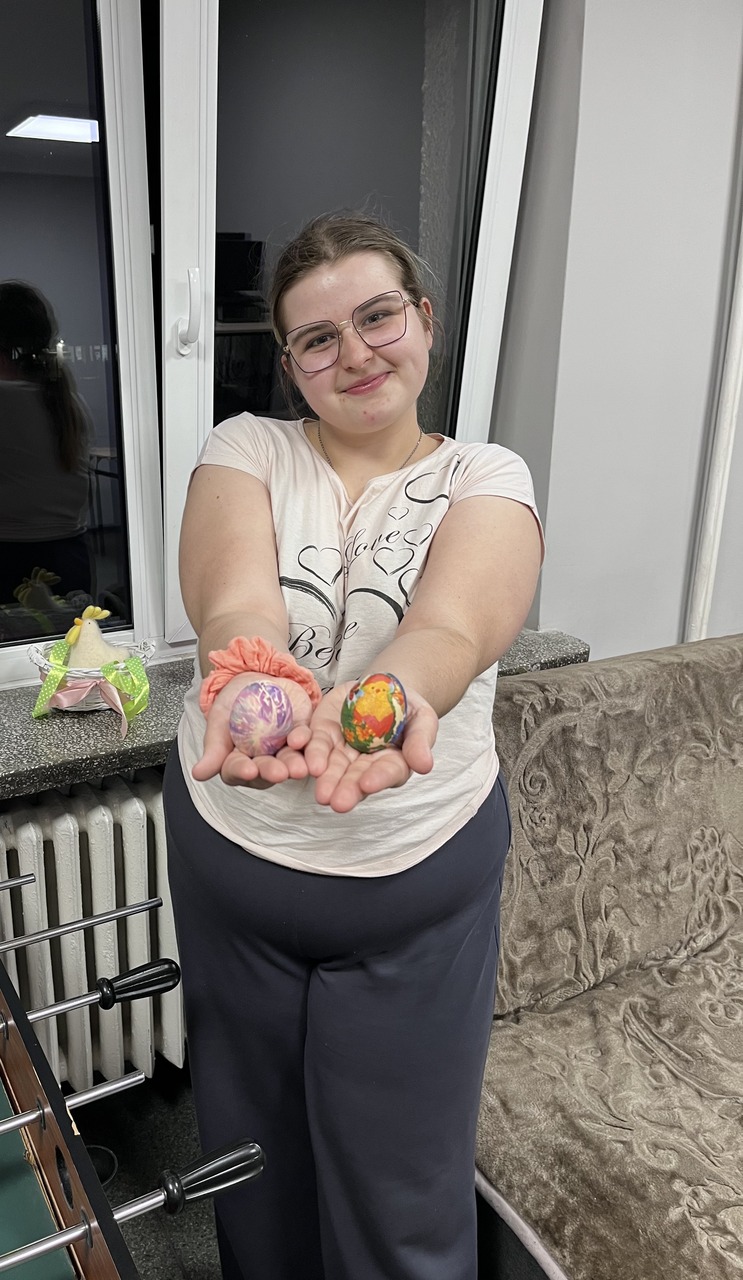 4 zdjęcie. Wychowanka prezentuje udekorowane przez siebie jajka.
