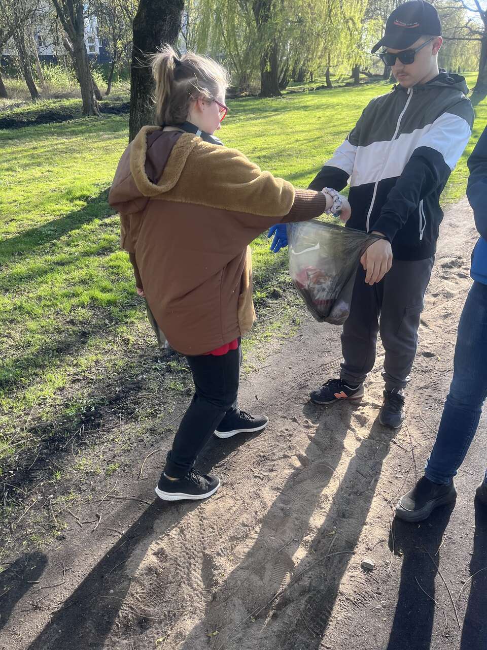 2.       Wychowanka wrzuca plastikowe śmieci do worka trzymanego przez kolegę.

