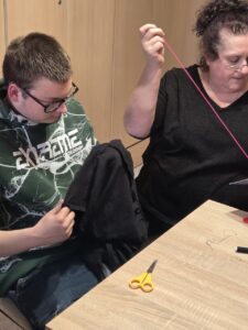 Zd.3
Chłopiec zszywa rozdarcie w swoich spodenkach.