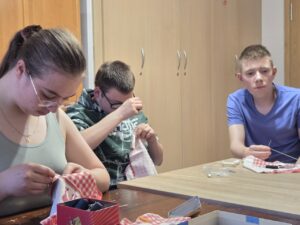 Zd.1
Chłopiec i dziewczynka zszywają pęknięcie w materiale.