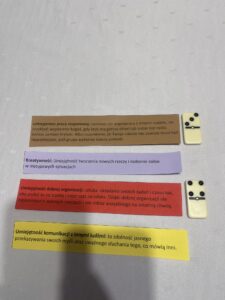 zdjęcie 4. Na stole leży kilka kolorowych karteczek z wypisanymi umiejętnościami.
