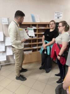 Zdj. 4 Pracownik urzędu pokazuje wychowankom przykładowe druki do wypełnienia.