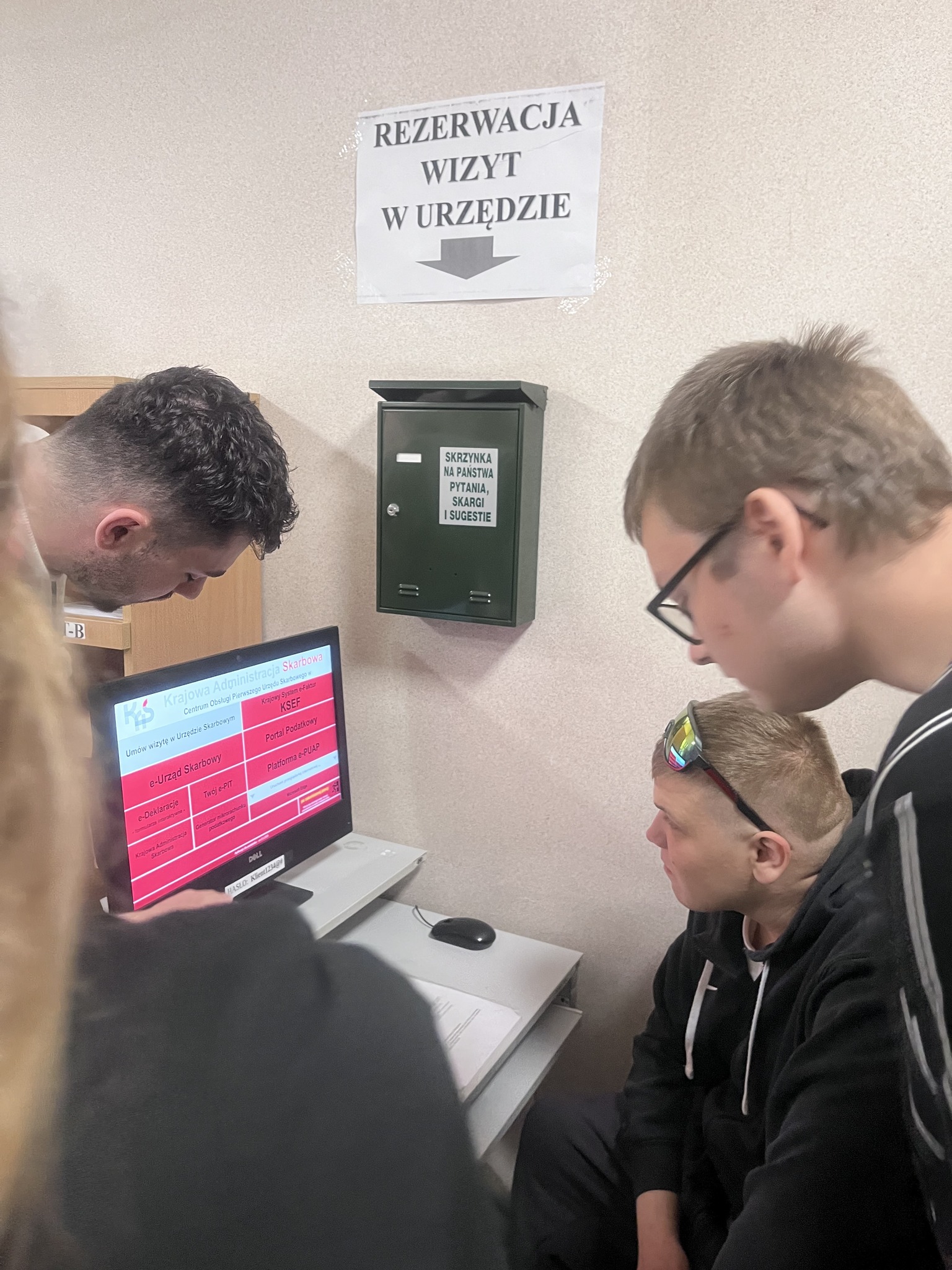 Zdj. 7 Pracownik urzędu pokazuje wychowankom na komputerze, jak mogą złożyć wniosek przez internet.
