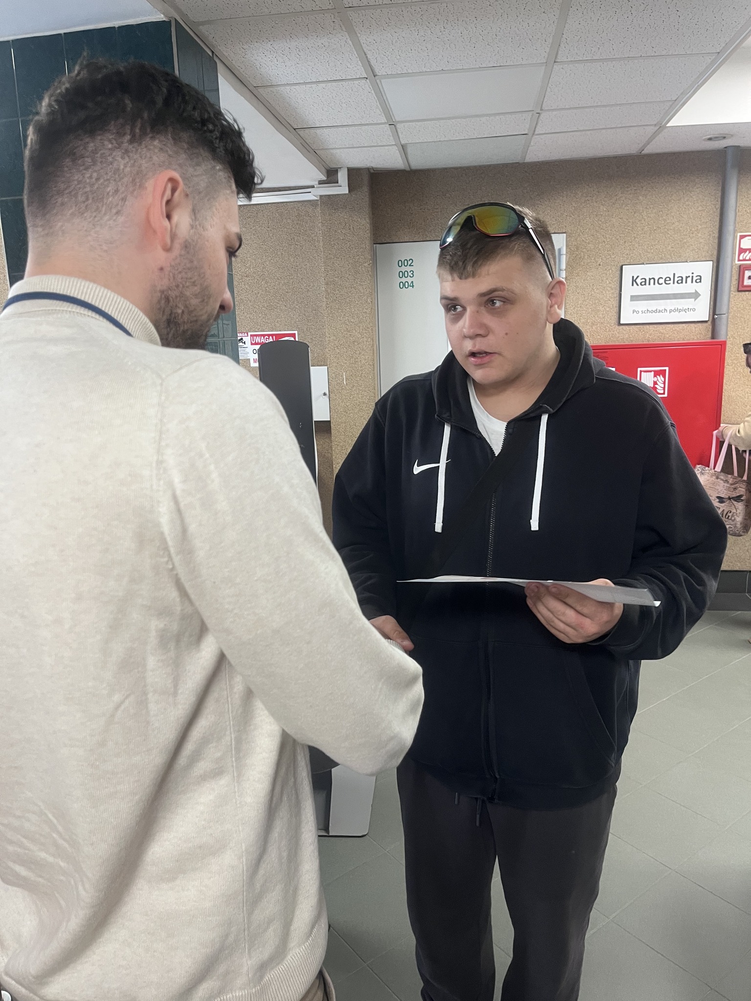 Zdj. 9 Wychowanek wręcza pracownikowi urzędu pisemne podziękowanie.