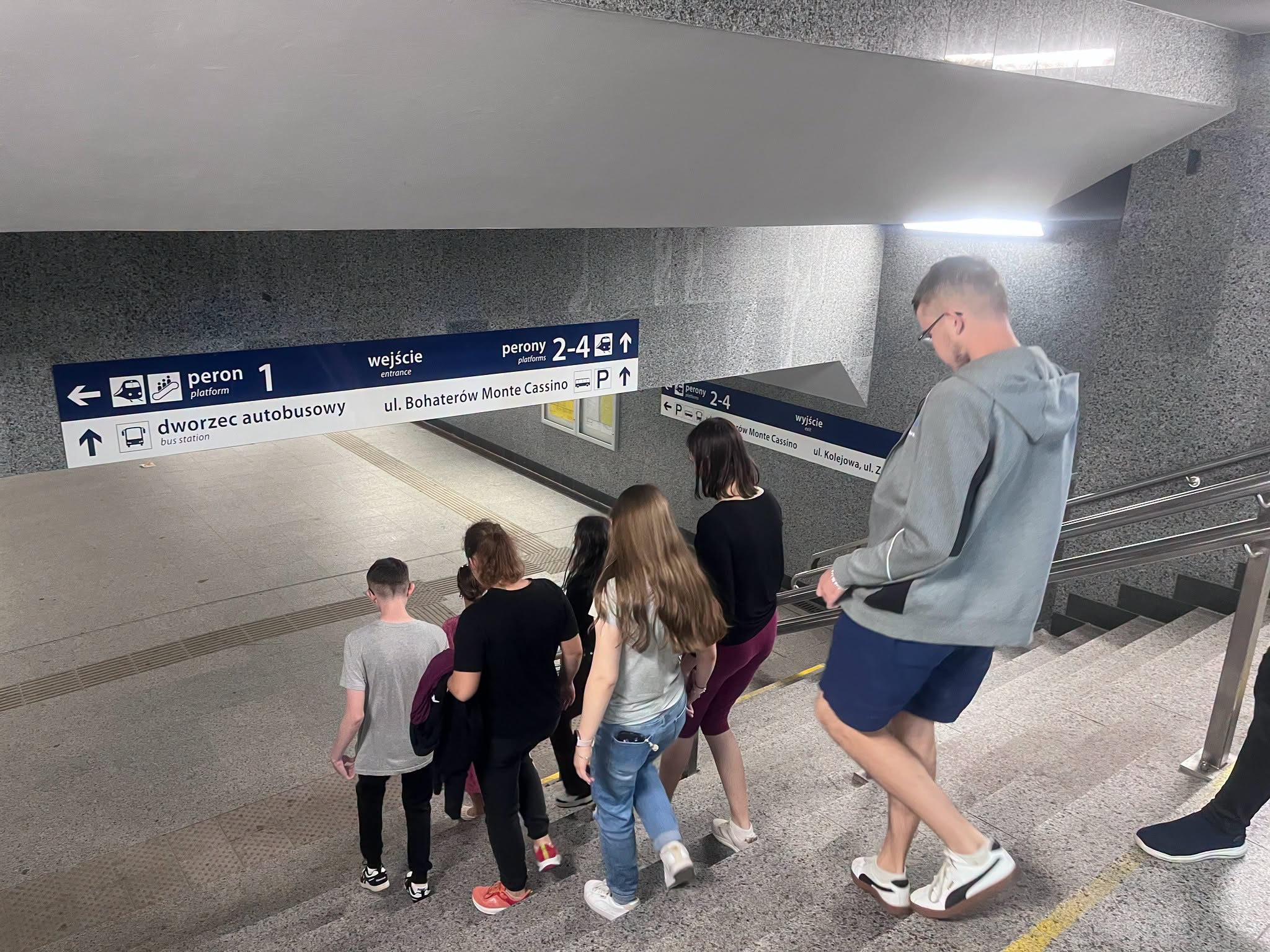 Zdj.3 Młodzież schodzi  po schodach przejściem podziemnym na Dworcu PKP.

